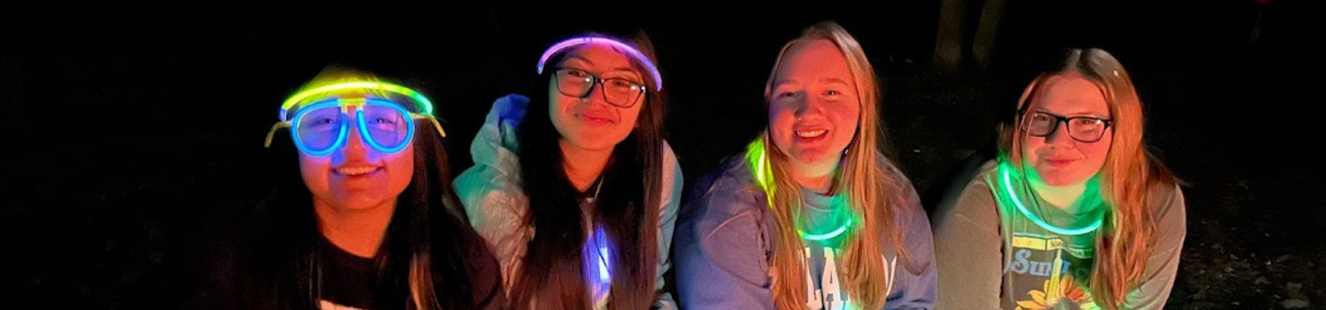  four older girls wearing neon glow in the dark items 