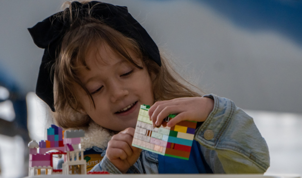 girl playing with a lego structure