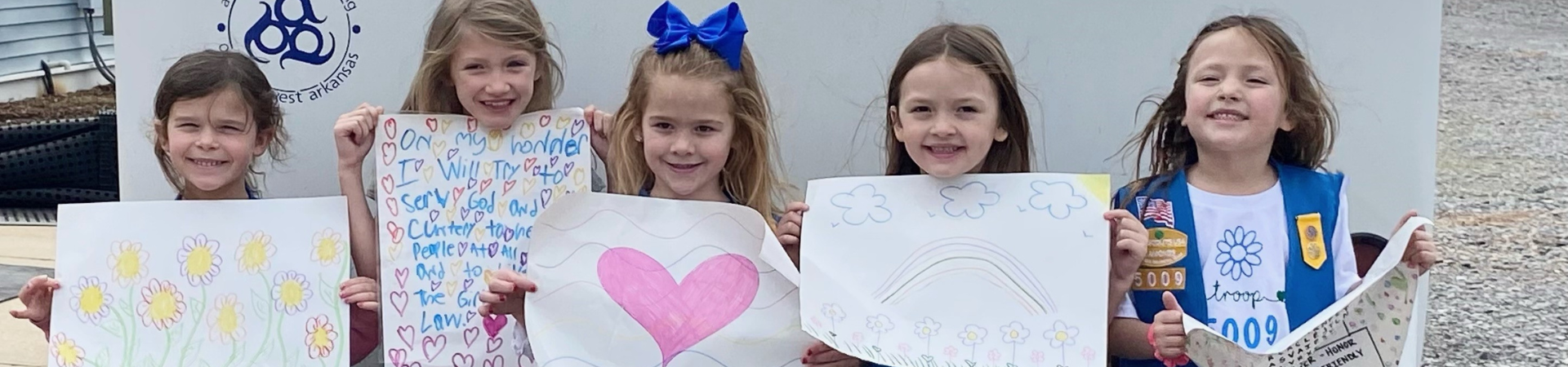  Five daisies stand in front of a van with drawings and signs 