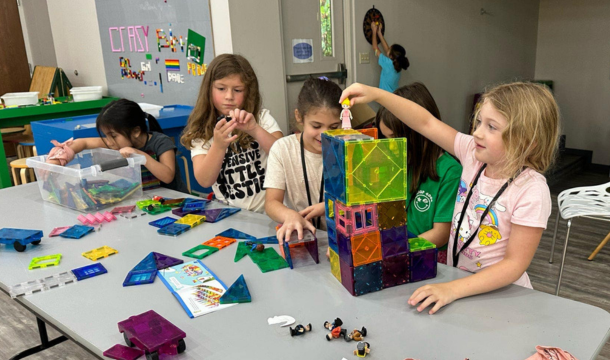 Four Girl Scouts working on activities at a long table