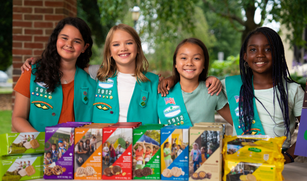 four girl scouts at a cookie booth