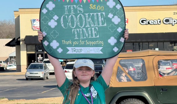 four girl scouts at a cookie booth