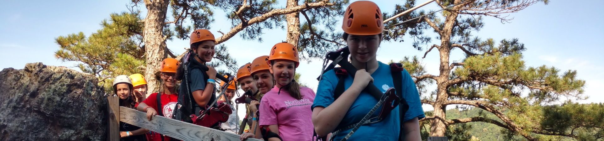  Group of girls wearing orange helmets and climbing gear 