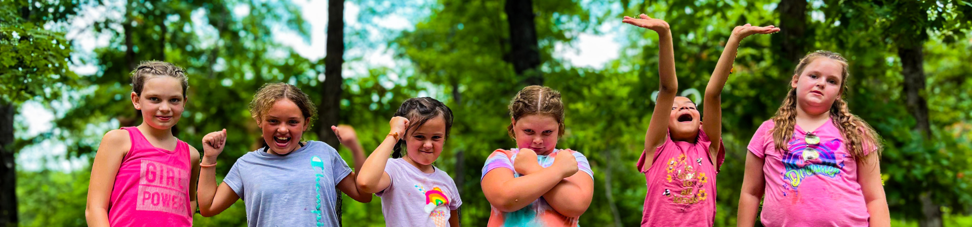  group of 5 girl scouts hold hands at a cemetery where they have placed flags 