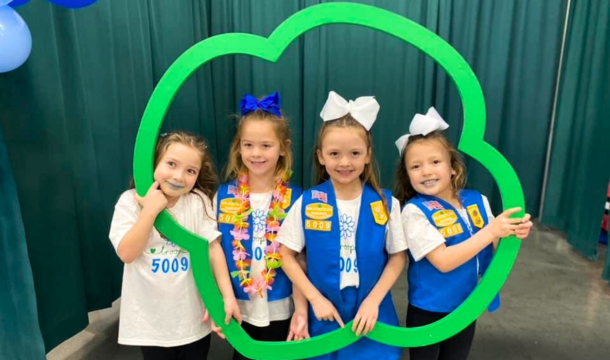 Daisy Girl Scouts standing inside of a Trefoil frame at a Girl Scout event