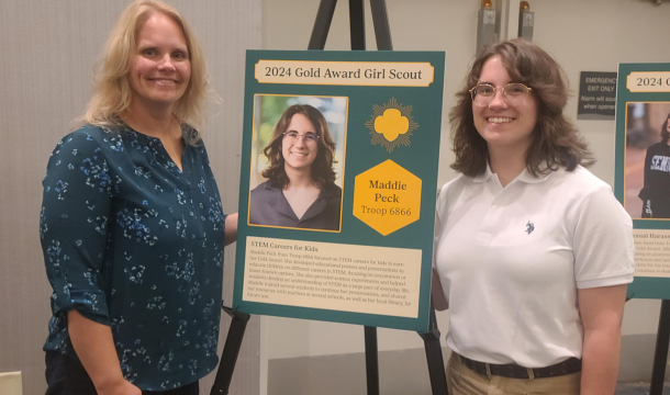 gold award girl and an adult posing with a poster about her project