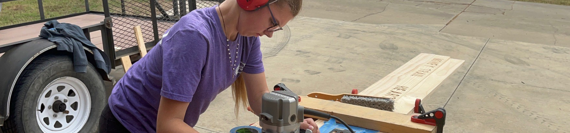  girl using a router on a woodworking project 