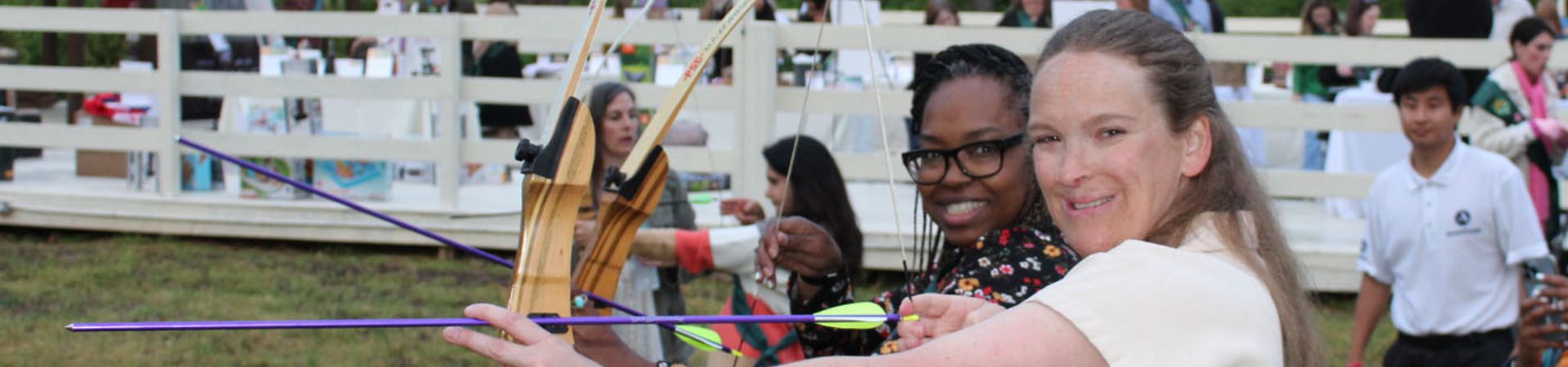  adult draws back bow string at archery range 